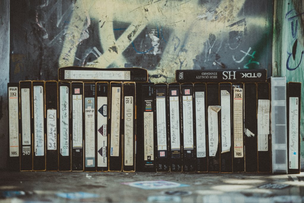 a line of VHS home videos against a wall